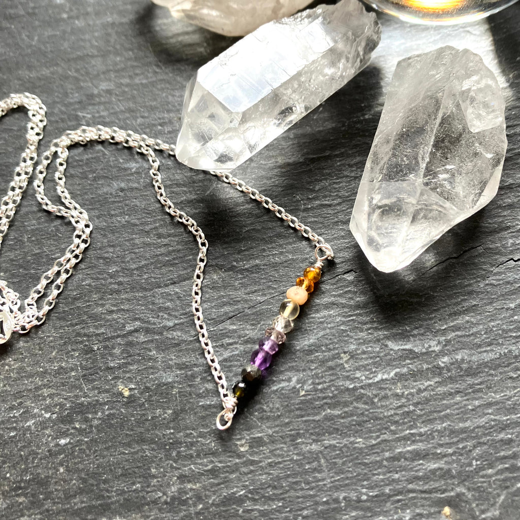 Necklace with colorful beads on a dark surface with crystals