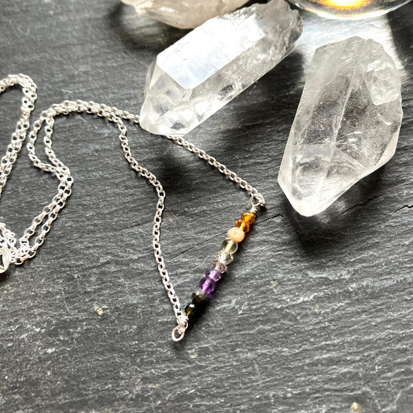Necklace with colorful beads on a dark surface with crystals